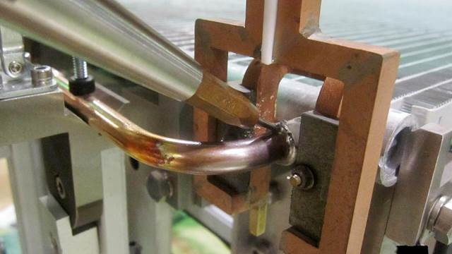 Induction brazing of a copper tube to an aluminium heat exchanger. 